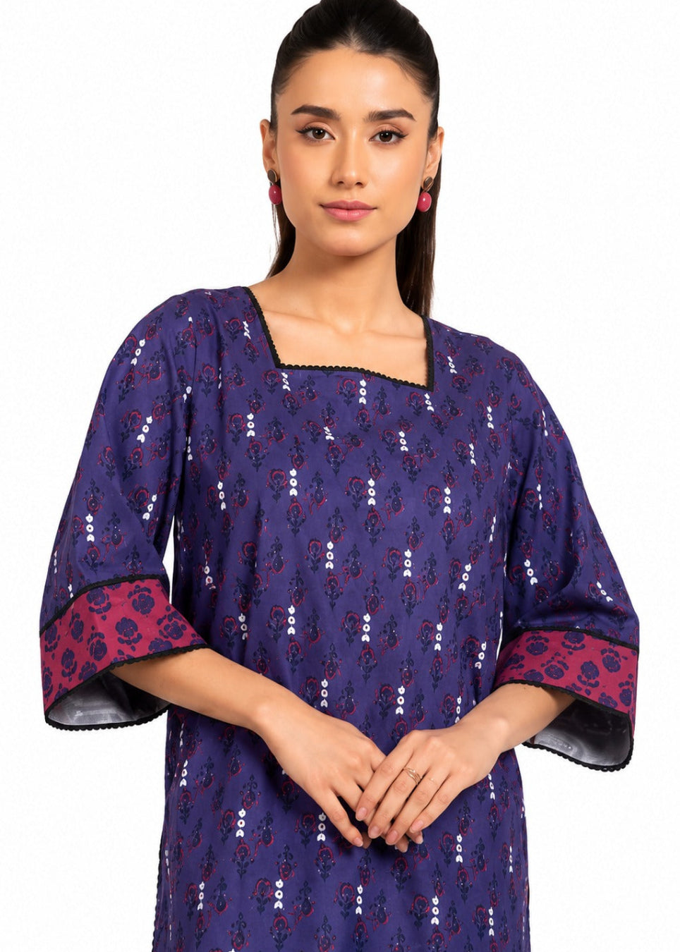 A woman modeling a navy blue cotton kurta with small white and red floral prints, featuring wide three-quarter sleeves with red patterned cuffs and black trim.