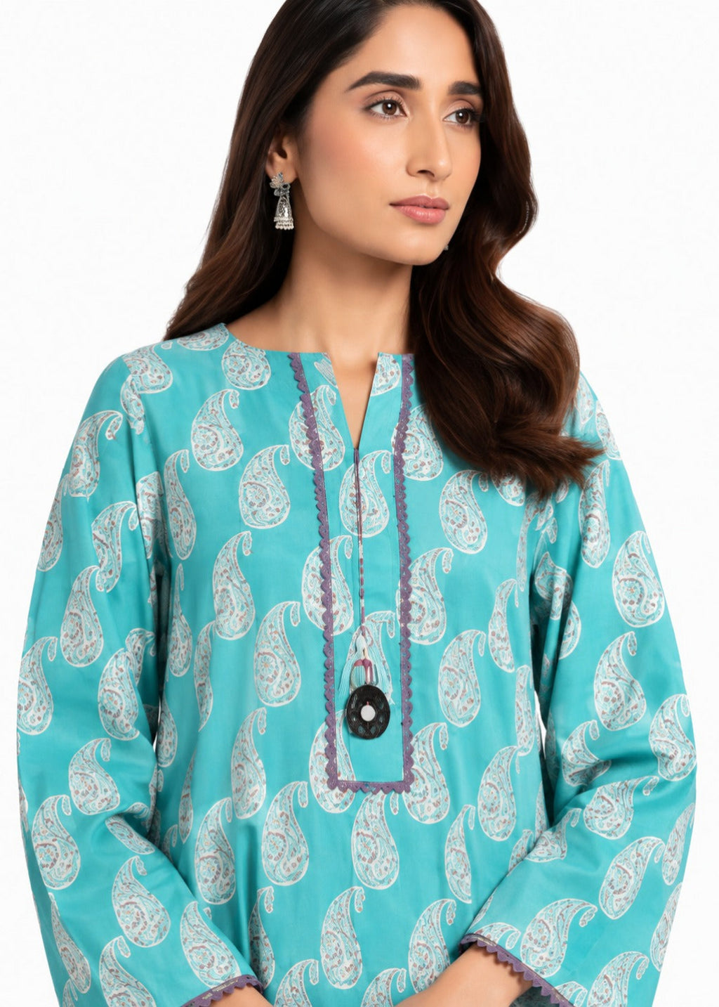 A woman wearing a turquoise blue long-sleeve kurta with a white paisley pattern, featuring a split neckline with purple embroidered trim and a black circular pendant necklace.