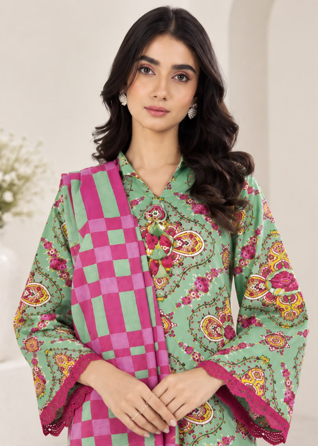 A woman modeling a green printed ethnic kurta with a pink checkered dupatta, set against a soft beige background.