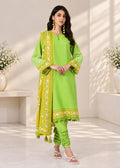 A woman models a bright lime green ethnic three-piece suit set, featuring a kurta with matching printed dupatta and pleated pants, set against a warm, sunlit studio background.