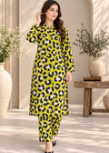 A woman models a bright yellow-green kurta set with a black and white leopard print pattern, styled with matching pants and black flat shoes in an elegant indoor setting with plants.
