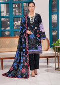 A woman models a black 3-piece printed salwar kameez suit with a matching dupatta. The suit features vibrant blue, pink, and purple floral patterns, paired with black trousers and accessorized with a multi-strand pearl necklace.