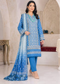 A woman models a traditional blue Indian salwar kameez suit set with a matching dupatta in a beautifully decorated indoor setting. The set features a blue printed kurta, solid blue trousers, and a blue patterned dupatta.