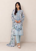 A woman modeling a light blue floral printed traditional outfit with a long kurta, matching pants, and a dupatta, standing against a plain beige studio background.