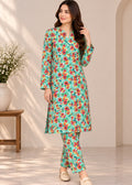 A woman models a two-piece floral printed kurta and trouser set. The outfit features a mint green base with a vibrant pattern of red, orange, and yellow flowers with green leaves.
