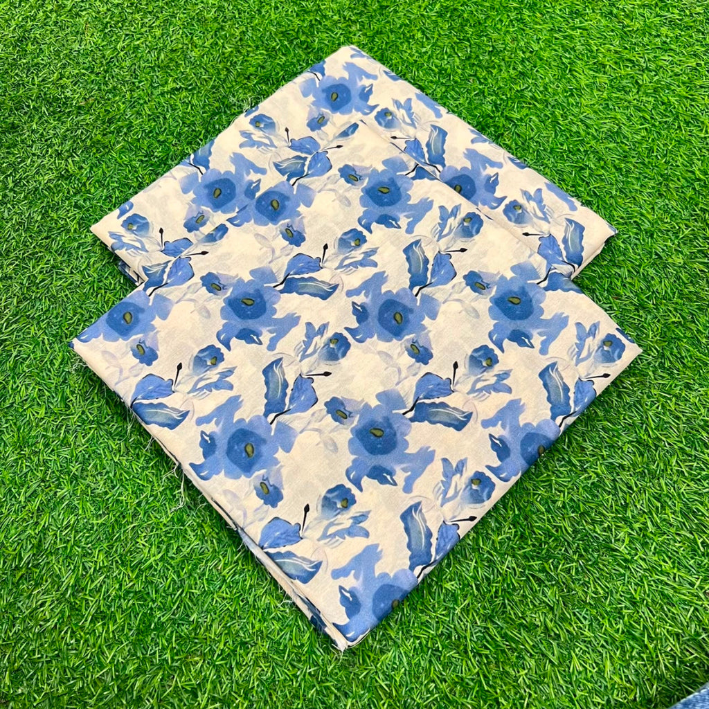 Two square fabric pieces with a blue floral pattern on a cream background, laid flat on green artificial grass.