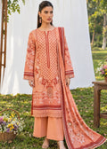 A woman modeling a peach-colored traditional three-piece suit set with intricate red and white embroidery, featuring a kurta, wide-leg pants, and a matching dupatta, set against an outdoor garden backdrop with a white drape.