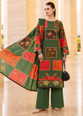 A woman models a three-piece traditional South Asian salwar kameez set. The outfit features a forest green kurta with red and orange patchwork panels containing floral prints, matching green wide-leg trousers, and a coordinating green dupatta with red and orange patchwork squares.