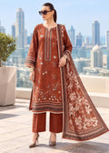 A woman models a rust-orange 3-piece salwar kameez suit set with white floral embroidery and a matching dupatta, set against a blurred city skyline background.