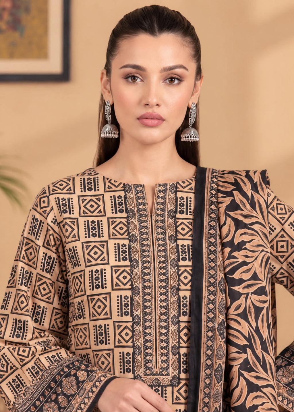 A woman modeling a beige and black printed ethnic kurta with matching printed dupatta, featuring geometric patterns on the front and a leafy print on the side.