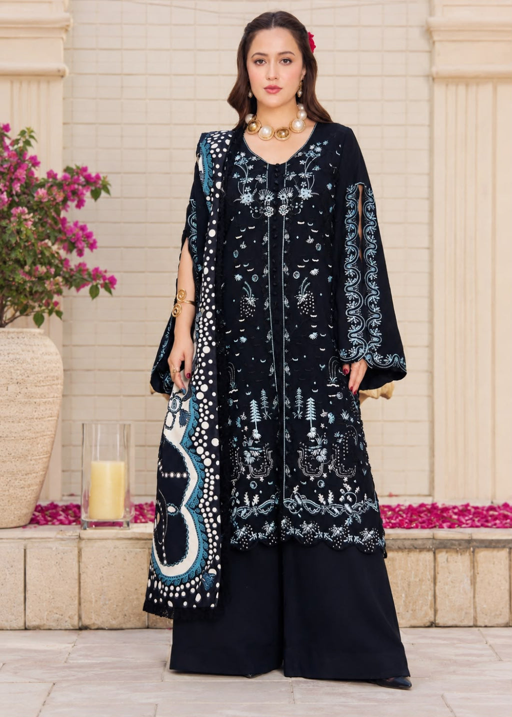A woman models a traditional three-piece beige ethnic suit with brown floral embroidery and a matching dupatta, set against a beige wooden grid wall background.