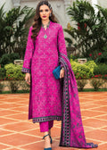 A woman models a bright pink traditional South Asian outfit with matching trousers and a patterned dupatta, standing in an outdoor garden courtyard.