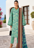 A woman models a traditional three-piece salwar kameez suit set in an outdoor courtyard setting. The set features a mint green and teal floral printed kurta, matching trousers, and a coordinating dupatta with a multicolor patterned border.