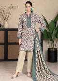 A woman models a three-piece salwar kameez suit set featuring a beige kurta with a multicolor floral print and teal borders, paired with beige trousers and a matching printed dupatta, in a styled indoor setting.