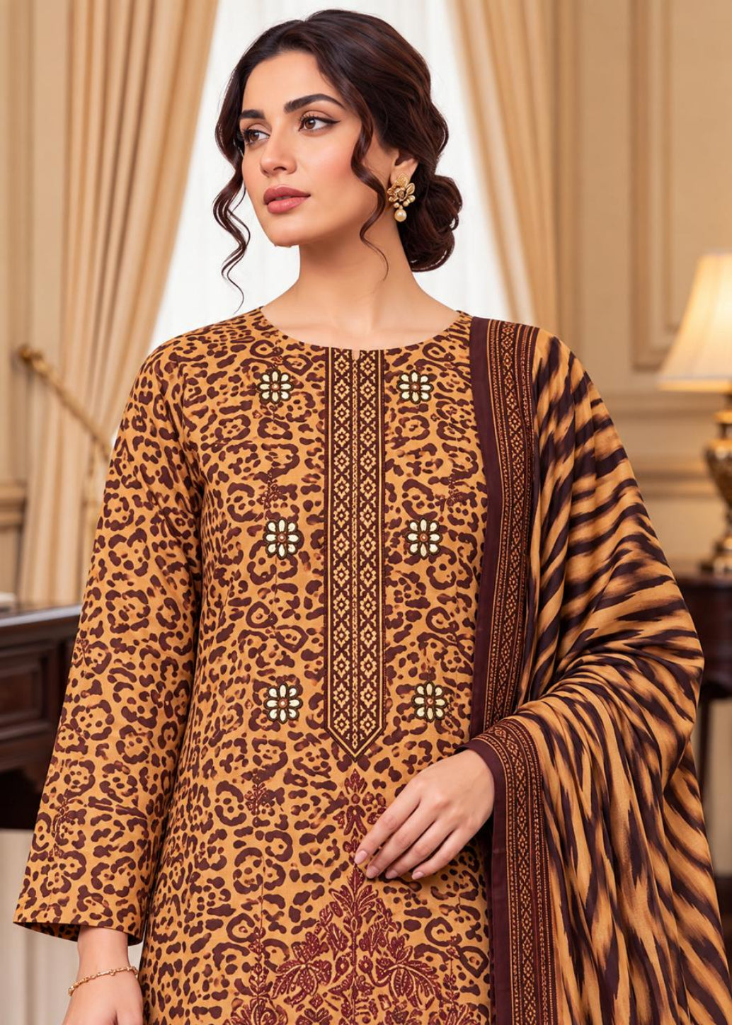 A woman models a brown and beige animal-print salwar kameez suit with a matching patterned dupatta in an elegant indoor setting.