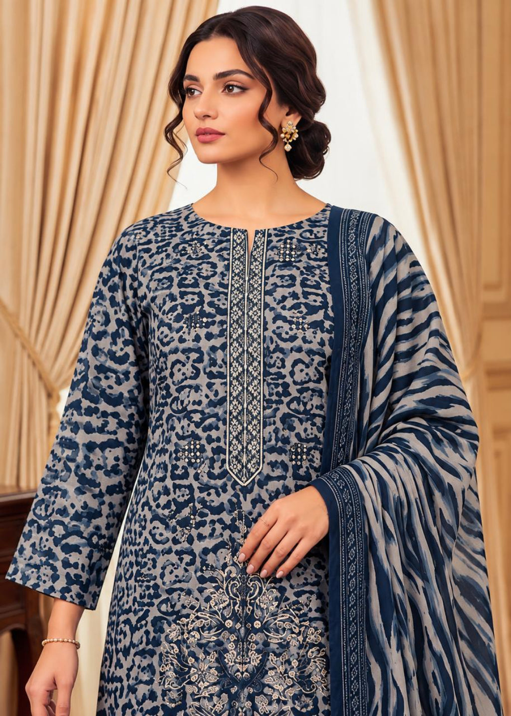 A woman models a navy blue and gray printed ethnic salwar kameez suit with a matching dupatta, set against a background of beige curtains.