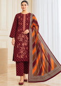 A woman models a traditional three-piece salwar kameez suit in deep maroon with floral embroidery, paired with matching trousers and a striped orange, brown, and maroon dupatta.