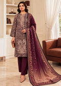 A woman models a traditional Indian salwar kameez suit set in a bright, elegant room. The set features a deep maroon kurta and trousers with a beige and brown leopard print kameez overlay, and a matching maroon dupatta with a beige-to-brown gradient and floral border.