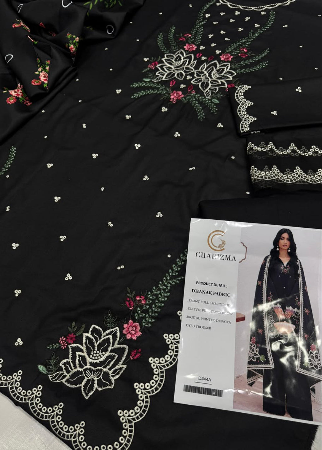 Black embroidered fabric with white floral lace borders, green leafy details, and pink and red floral accents, shown alongside a printed product card labeled CHAPZMA.
