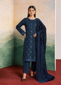 A woman models a dark navy blue traditional Indian salwar kameez suit set, featuring a long-sleeved kurta with subtle floral embroidery, matching trousers, and a patterned navy blue dupatta, set against a scenic backdrop with a painted mountain mural.