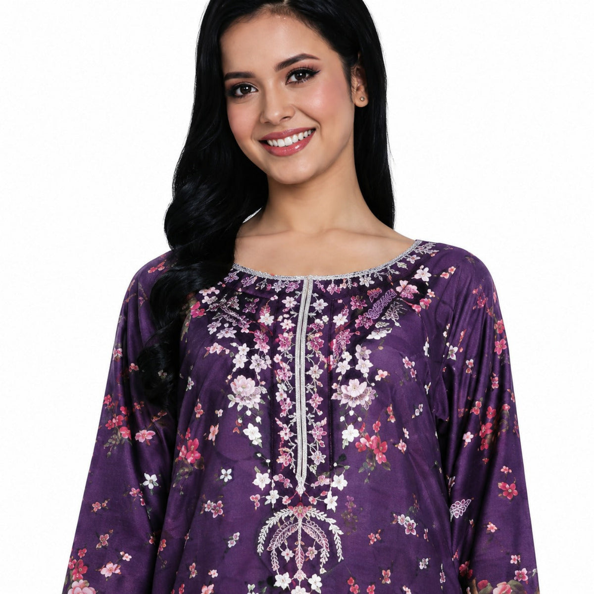 A woman wearing a purple long-sleeve tunic top with a floral print and silver embroidered details on the neckline and front, set against a plain white background.