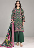 A woman models a three-piece traditional Indian salwar kameez suit set. The set features a dark green printed kurta with pink and yellow floral motifs, solid green wide-leg trousers, and a matching printed green dupatta with a pink border.