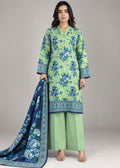 A woman models a traditional three-piece salwar kameez suit set. The set features a light green kurta with blue floral prints and borders, solid light green wide-leg trousers, and a navy blue dupatta with a blue floral pattern and border.