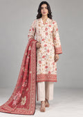 A woman modeling a traditional three-piece salwar kameez suit set. The set features a light beige kurta with a red and pink floral print and border, paired with beige trousers and a matching red dupatta with a floral print and gold border.