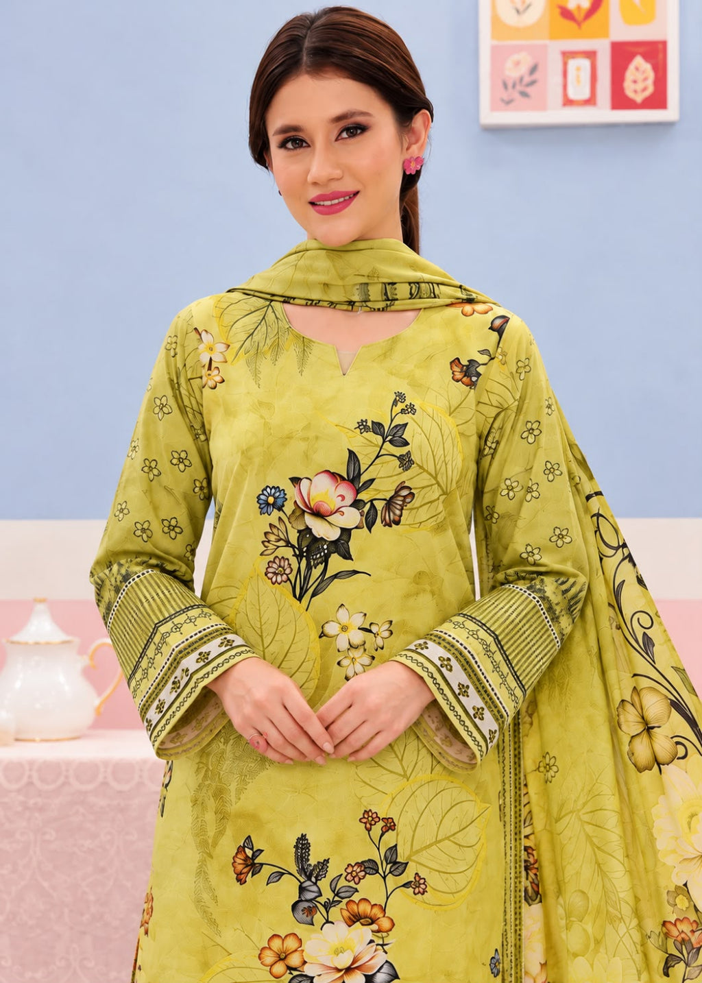 A woman modeling a traditional Indian salwar kameez set in olive green, featuring floral embroidery, printed motifs, and a matching dupatta.