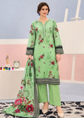 A woman models a light green three-piece ethnic suit set featuring a floral printed kurta, matching pants, and a coordinating dupatta, set against a pastel studio backdrop.