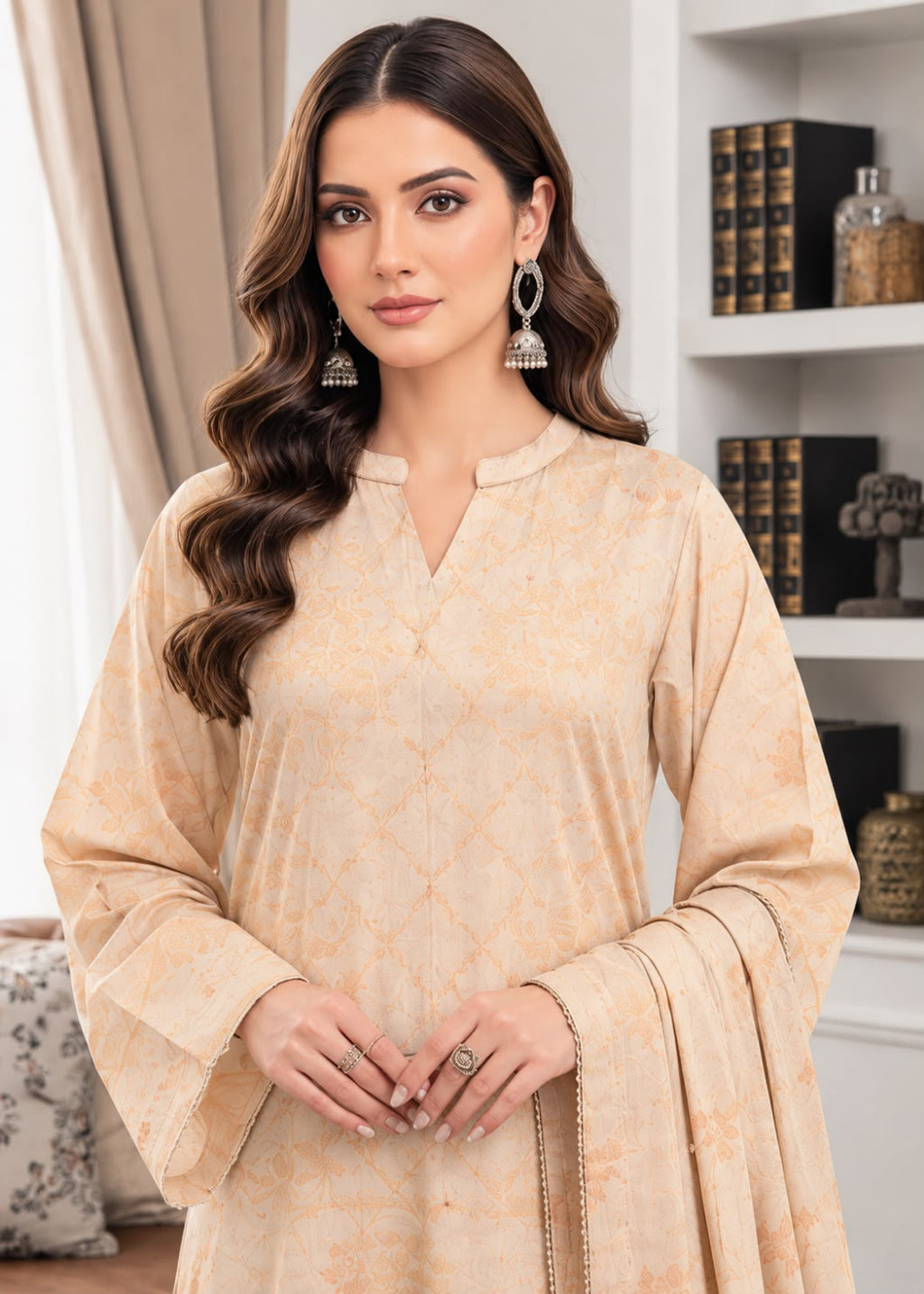 A woman modeling a beige printed traditional kurta with wide bell sleeves and a V-neckline, styled with matching dupatta and silver earrings in an indoor setting.