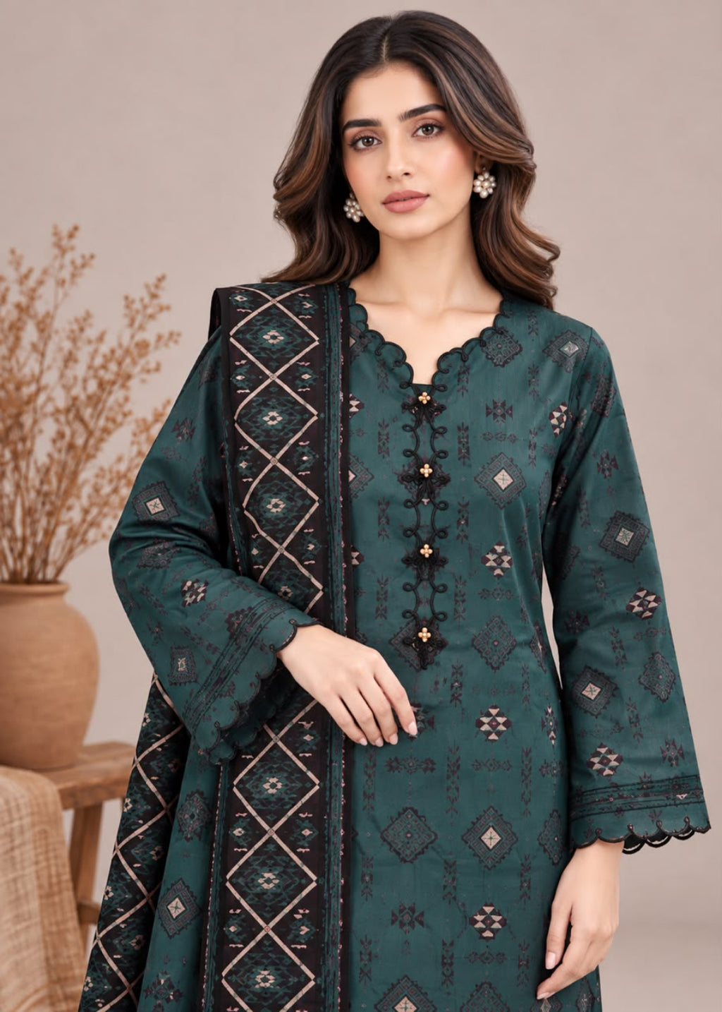 A woman modeling a dark teal green ethnic kurta with intricate black and beige geometric embroidery, paired with a matching embroidered dupatta, set against a neutral beige background.