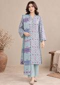 A woman models a light blue three-piece salwar kameez suit set with pink and purple geometric patterns, featuring a long kurta, matching trousers, and a dupatta, set against a neutral beige background with decorative props.