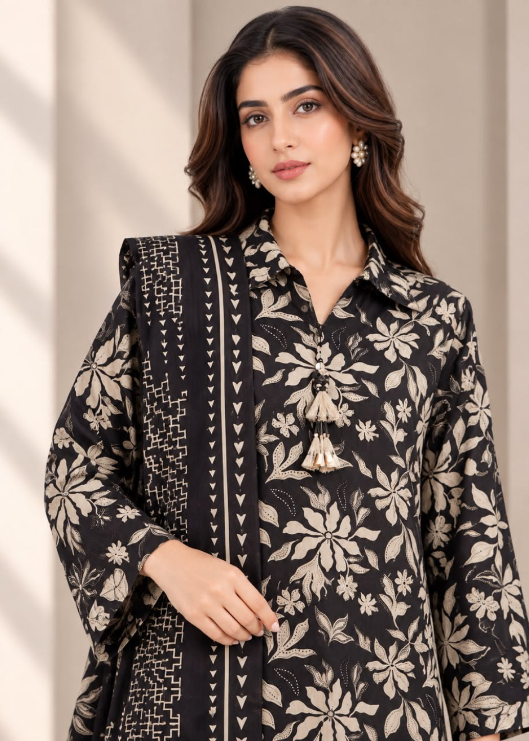 A woman modeling a black and beige floral printed kurta with a matching patterned dupatta, set against a neutral beige background.