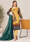 A woman models a three-piece traditional South Asian salwar kameez suit. The kurta is mustard yellow with a dark floral print and patterned sleeves, paired with matching yellow trousers and a teal dupatta with silver embroidery.