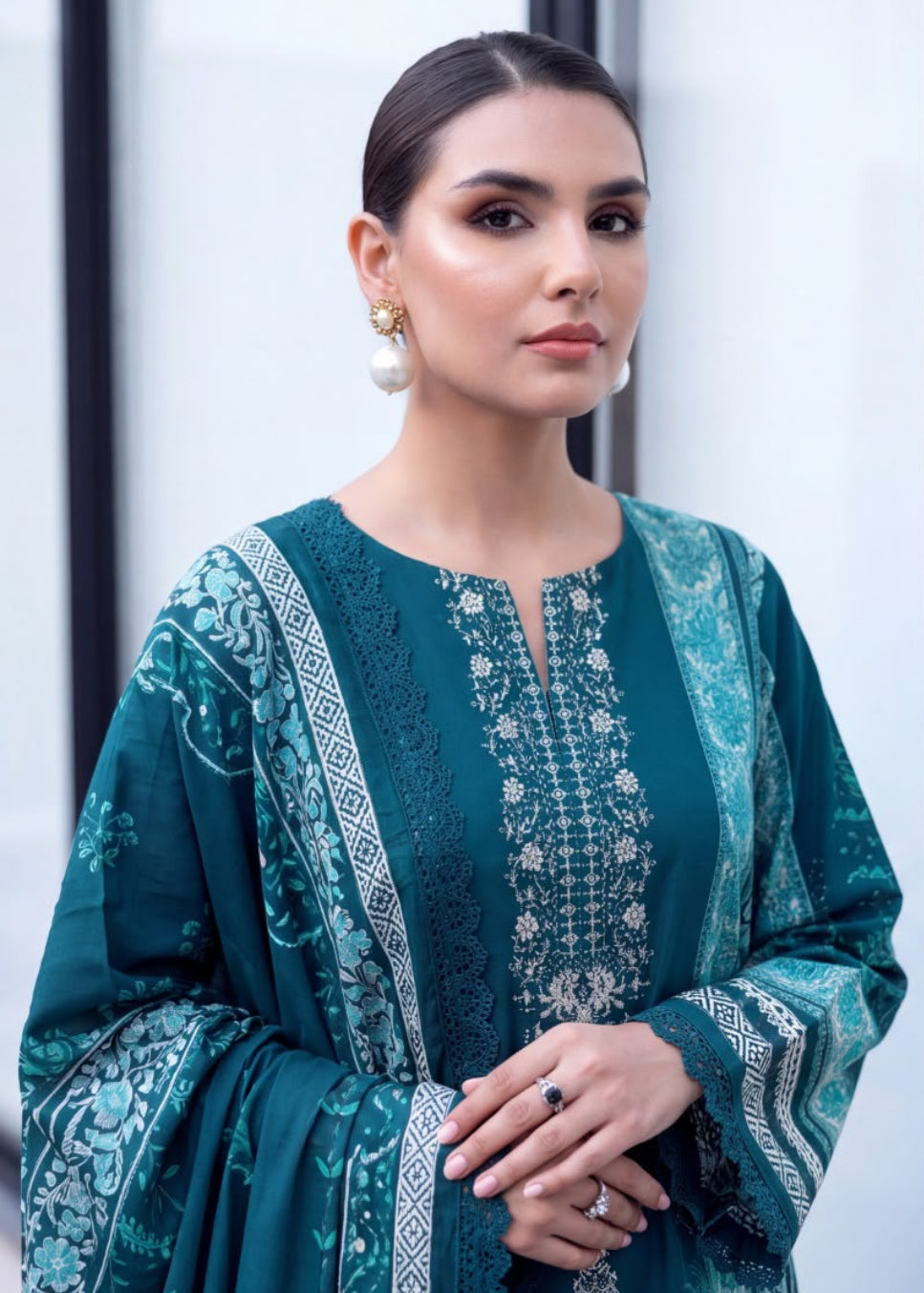 A woman modeling a teal green embroidered traditional outfit with matching pants and dupatta, shown in a split portrait and full-body pose on a modern balcony.