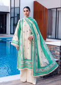 A woman models a traditional South Asian outfit consisting of a cream-colored kurta with colorful floral embroidery, matching cream trousers, and a vibrant green dupatta with intricate borders, standing next to a swimming pool.
