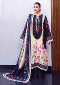 A woman models a traditional South Asian salwar kameez suit with a floral print. The outfit features a cream-colored kurta with pink and green floral embroidery, a navy blue yoke with gold embroidery, and a matching navy blue dupatta with white lace borders and pink floral prints.
