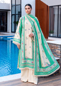 A woman models a traditional South Asian outfit consisting of a cream-colored kurta with green and floral embroidery, matching cream trousers, and a green dupatta with intricate borders, set against a modern poolside background.