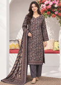 A woman models a traditional Indian salwar kameez suit set in a decorated indoor setting. The set features a dark brown kurta with a detailed multicolor floral print, matching dark brown trousers, and a coordinating dupatta with a printed border.