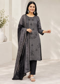 A woman modeling a dark gray three-piece salwar kameez suit with floral embroidery, featuring a long kurta, straight pants, and a matching dupatta, set against a bright, modern indoor background.