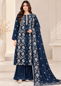A woman modeling a navy blue traditional Indian salwar kameez suit with beige floral embroidery, paired with matching wide-leg pants and a long dupatta, in a neutral indoor setting.