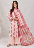 A woman modeling a light pink three-piece traditional outfit with matching printed dupatta, featuring a kurta with small motifs, wide-leg pants, and a draped scarf with a detailed pink border and floral print.