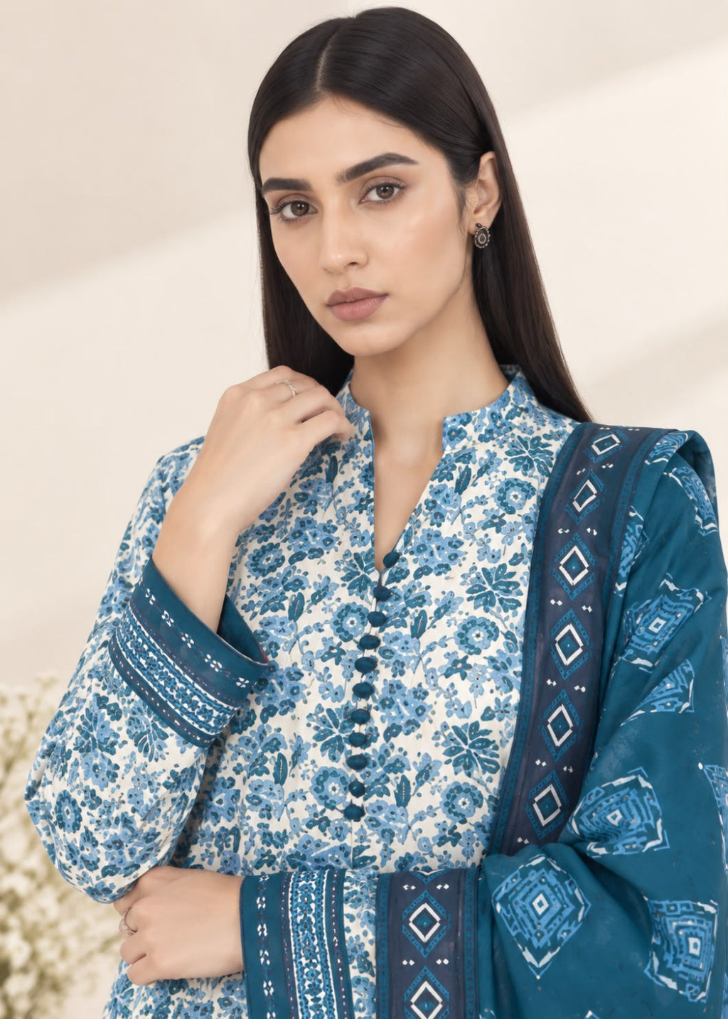 A woman modeling a traditional South Asian salwar kameez set in blue and white floral print, featuring a mandarin collar, buttoned front, and matching printed dupatta.