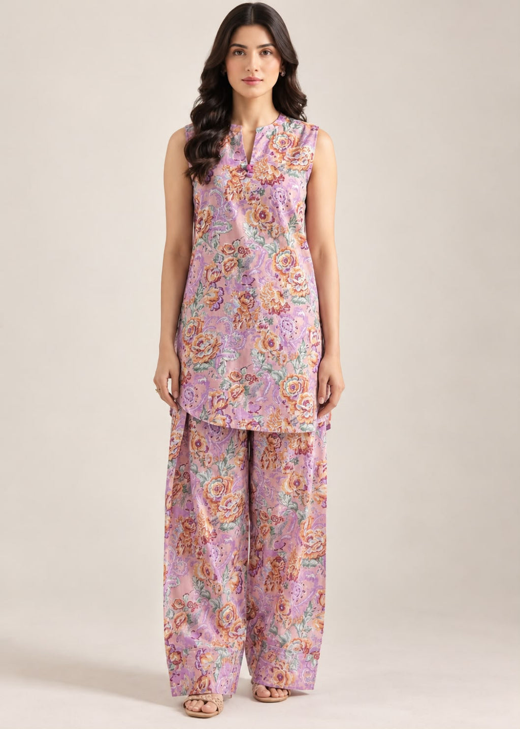 A woman modeling a sleeveless lavender floral kurta with matching wide-leg trousers, photographed against a plain light beige studio background.