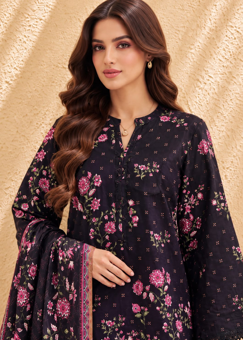 A woman wearing a dark navy floral salwar kameez suit with pink and green flowers, set against a textured beige background.