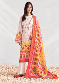 A woman models a traditional three-piece salwar kameez suit in cream and yellow, featuring red floral embroidery, a red-orange border, and a matching printed dupatta, set against a light gray studio backdrop with decorative pebbles at the bottom.