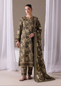 A woman models a three-piece traditional outfit with a matching dupatta. The set features an olive green base with intricate gold and blue floral embroidery, paired with matching trousers and a long draped dupatta with gold borders.