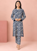 A woman modeling a navy blue and white zebra-print kurta set with matching pants, standing against a solid pink studio backdrop.