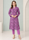A woman modeling a purple and black floral print kurta with matching purple pants, standing in a clean, modern studio setting with light gray walls and white columns.